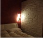 Camera da letto.Finiture: parete con velatura rossa, parete laterale in pietra a spacco naturale stampata in gesso.<br />Illuminazione: “A vele spiegate” bianca.